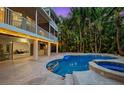 Private outdoor pool with a spa, covered patio, and lush tropical landscaping at 294 Kentucky Ave, Crystal Beach, FL 34681