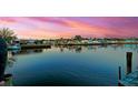 Scenic waterfront view with a calm blue canal reflecting the colorful homes and sky at 294 Kentucky Ave, Crystal Beach, FL 34681