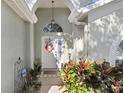 Inviting front entry with arched doorway and colorful front yard plants at 29737 Fog Hollow Dr, Wesley Chapel, FL 33543