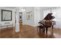 Elegant foyer with hardwood floors, a grand piano, and a decorative chandelier creating a welcoming entrance at 3325 W Wallcraft Ave, Tampa, FL 33611