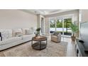 Cozy living room with neutral tones, a comfortable sofa, stylish decor, and sliding glass doors to the outside at 3717 Nandina Cir, Sun City Center, FL 33573