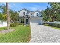 Charming two-story home with a manicured lawn and gray brick driveway at 4251 W Roland St, Tampa, FL 33609