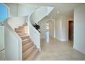 Bright foyer features a winding staircase, white walls, and light tile flooring, enhancing the home's elegant aesthetic at 4321 S Renellie Dr, Tampa, FL 33611