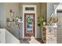 Inviting front door adorned with a wreath, decorative baskets, and stone column accents at 7209 Meeting House Ln, Apollo Beach, FL 33572