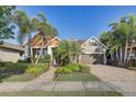 Charming front of the home with a well-manicured lawn, mature landscaping, and a brick paved driveway at 7209 Meeting House Ln, Apollo Beach, FL 33572