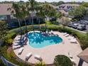 Community swimming pool with multiple lounge chairs and palm trees around the perimeter at 7826 66Th N Way, Pinellas Park, FL 33781