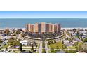 Aerial view of the oceanfront high rise with beachfront access and a roundabout parking area at 880 Mandalay Ave # C908, Clearwater Beach, FL 33767