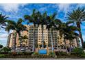 Stunning exterior of beachfront high rise building with palm trees and meticulously manicured landscaping at 880 Mandalay Ave # C908, Clearwater Beach, FL 33767