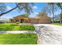 Inviting single-story home with lush green lawn and a three-car garage at 8933 Crescent Forest Blvd, New Port Richey, FL 34654