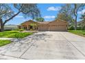 Beautifully landscaped single-story house with a three-car garage and wide driveway at 8933 Crescent Forest Blvd, New Port Richey, FL 34654