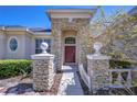 Home featuring a stone pillar entryway with a red front door at 9211 Everwood Ct, Tampa, FL 33647