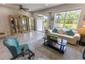 Bright living room with tile flooring, large windows, and sliding glass doors to the patio at 9660 Sweetwell Pl, Riverview, FL 33569