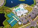 Fantastic aerial view of community amenities, including a pool, tennis courts, and a lake with a fountain at 9921 Pier Point Ter, Parrish, FL 34219