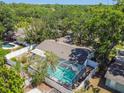 Aerial view of a beautiful home with a screened-in pool, surrounded by lush greenery and a privacy fence at 10314 Lake Carroll Way, Tampa, FL 33618