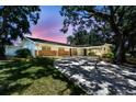 Inviting single-story home showcasing a brick facade, a convenient carport, and a mature tree-lined yard at 10314 Lake Carroll Way, Tampa, FL 33618