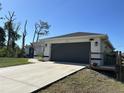 Nice one story home featuring a modern two car garage and neutral color palette with a well kept lawn at 12021 Coleman Ave, Port Charlotte, FL 33981