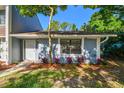 A charming townhome entrance highlighted by lush greenery and colorful landscaping at 1236 Abbey Crescent Ln, Clearwater, FL 33759
