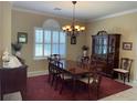 Traditional dining room with large window, elegant chandelier, and stylish furniture at 12619 50Th E Ct, Parrish, FL 34219