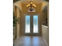 Grand foyer with decorative glass doors, chandelier, neutral walls, and ceramic tile flooring at 12619 50Th E Ct, Parrish, FL 34219