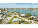 Aerial view of property near a waterfront community with calm waters, palm trees, and clear skies at 13313 3Rd E St, Madeira Beach, FL 33708
