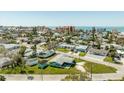 Aerial view of the property and surrounding neighborhood near the beach with clear, sunny skies at 13313 3Rd E St, Madeira Beach, FL 33708