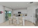 Bright kitchen with white cabinets, stainless steel appliances, a center island, and sliding door access to outdoor space at 13478 Tropical Breeze Way, Hudson, FL 34669