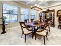 Elegant dining room featuring tile floors, coffered ceilings, and a stylish chandelier at 1509 Amarone Pl, Lutz, FL 33548