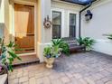 Charming front porch with seating area, featuring a brick paver floor, and decorative wreath at 1509 Amarone Pl, Lutz, FL 33548