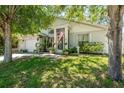 Inviting home exterior with lush lawn, blossoming trees and decorative garden accents at 15856 49Th N St, Clearwater, FL 33762