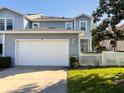 Charming two-story home with a well-manicured lawn, white picket fence, and attached two-car garage at 16127 Churchview S Dr, Lithia, FL 33547