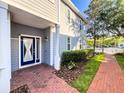 Inviting entryway featuring a stylish blue door, brick walkway, and lush landscaping at 16127 Churchview S Dr, Lithia, FL 33547