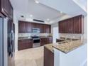 Bright kitchen with granite countertops, stainless steel appliances, and tile flooring at 16127 Churchview S Dr, Lithia, FL 33547
