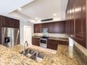 Spacious kitchen featuring stainless steel appliances, granite countertops, and dark wood cabinetry at 16127 Churchview S Dr, Lithia, FL 33547
