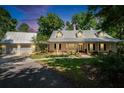 Beautiful home with metal roof and lush landscaping; illuminated by a stunning sunset at 16420 Iola Woods Trl, Dade City, FL 33523