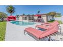 Relax by the pool with lounge chairs, an outdoor dining area, and a cozy cabana for the ultimate relaxation at 1650 Springdale Dr, Holiday, FL 34691