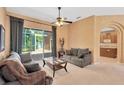 Comfortable living room with neutral tones, a ceiling fan, and sliding doors leading to the outdoors at 27054 Fordham Dr, Wesley Chapel, FL 33543