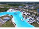 Breathtaking aerial view of a vibrant community lagoon with crystal-clear waters, resort-style amenities and surrounding neighborhood at 32046 Powderpuff Mimosa Dr, San Antonio, FL 33576