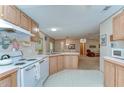 Cozy kitchen featuring white appliances and ample cabinet space, open to the dining area at 4041 Lane Rd, Zephyrhills, FL 33541