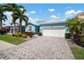 Charming, single-story home features lush landscaping, two-car garage, and a welcoming, light blue exterior at 424 Bahama Grande Blvd, Apollo Beach, FL 33572