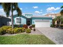 Charming, single-story home features lush landscaping, two-car garage, and a welcoming, light blue exterior at 424 Bahama Grande Blvd, Apollo Beach, FL 33572