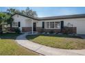 Single story home featuring brick accents and beautiful landscaping in the front yard at 6765 Ralston Beach Cir, Tampa, FL 33614