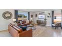 Relaxing living room with natural light, modern decor, tile floors, and a cozy seating arrangement at 6915 Broad River Ave, Land O Lakes, FL 34638