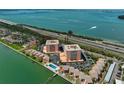 An aerial view showcases the condos, a pool, tennis court, and nearby coastal highway at 7430 Sunshine Skyway S Ln # 403, St Petersburg, FL 33711