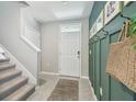 Hallway with tile floors, board and batten accent wall with hooks, and access to the upper level at 7591 Cypress Walk Dr, New Port Richey, FL 34655