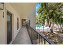 Exterior hallway leading to unit with a view of the pool and tropical plants at 105 4Th Ne Ave # 220, St Petersburg, FL 33701