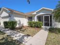 Single-story home featuring mature landscaping and screened front entryway at 10534 Collar Dr, San Antonio, FL 33576