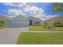 Well-manicured lawn and landscaping highlight this lovely home, complemented by a two-car garage at 13131 Early Run Ln, Riverview, FL 33578