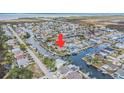 An aerial view of a waterfront neighborhood with water access and multiple houses with pools at 15528 Allmand Dr, Hudson, FL 34667