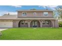 Home with a well-maintained lawn and arched front porch leading to the main door at 16528 Oley Ridge Ct, Tampa, FL 33624