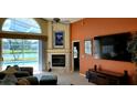 Cozy living room with fireplace, large windows, and view of the pool and water at 18412 Oriole St, Lutz, FL 33558